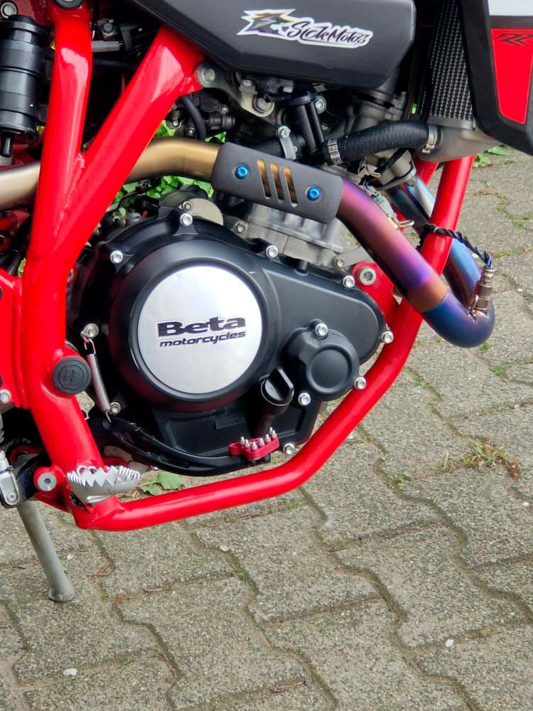 Close-up of a red motorcycle engine with 'Beta Motorcycles' branding.