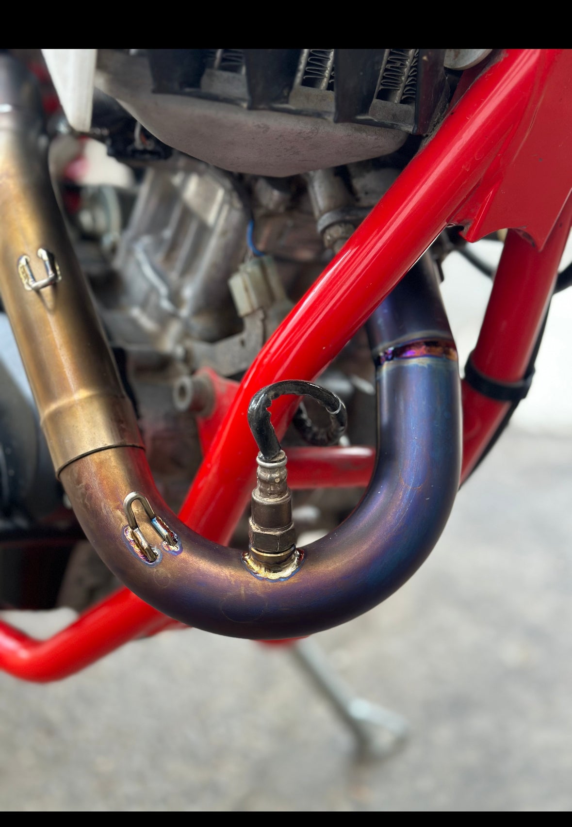 Close-up of a motorcycle exhaust system with red frame