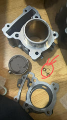 Mechanical parts on a wooden surface with red annotations.